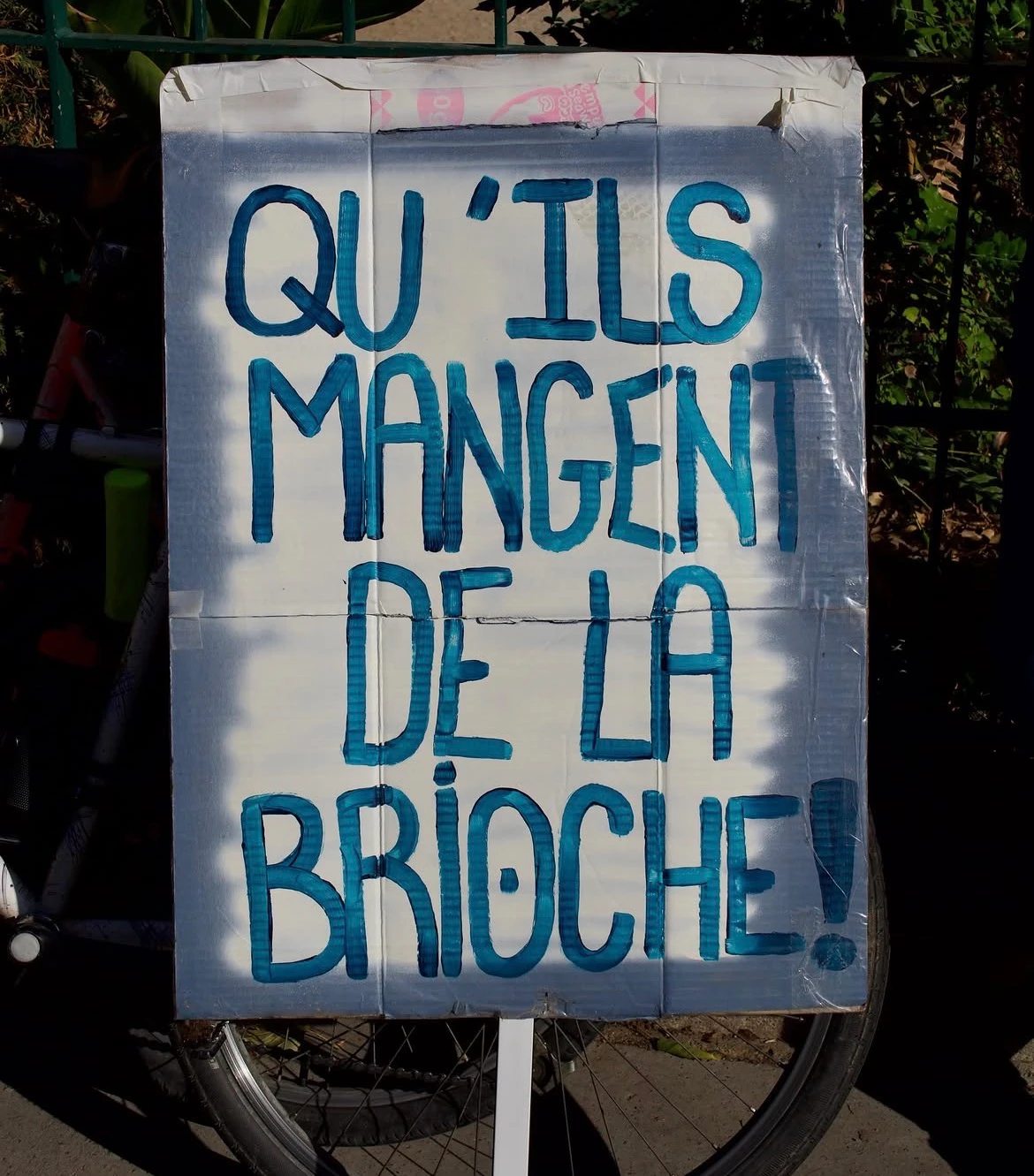 Protest sign reading: QU’ILS MANGENT DE LA BRIOCHE !